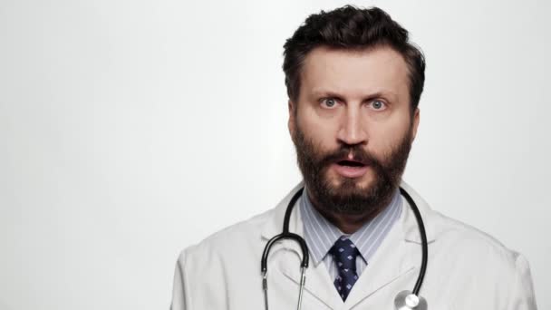 Doctor is surprised, shocked. Confused surprised man doctor on white background looking at camera and opens mouth and touches face with his hands — Stock Video