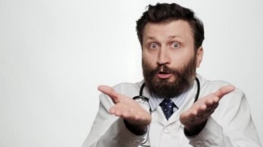 Doktor omuz silkme, bilmiyorum. Şaşkın doktor beyaz arka planda kameraya bakıyor ve duygusal olarak omuzlarını sıkıyor ve cehaletini göstermek için ellerini açıyor.