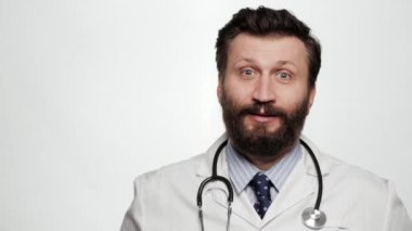 Doktor EVET duygu jesti. Heyecanlı, neşeli, beyaz arka plandaki doktor kameraya bakıyor ve duygusal olarak elini yumruk yapıp memnuniyetini ve muhtemelen zaferini gösteriyor.