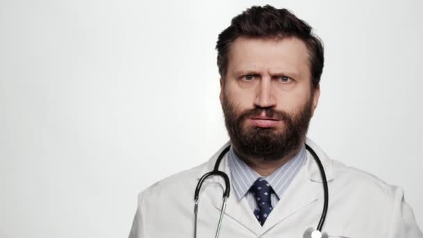 Doktor FACEPALM. Megdöbbent férfi orvos fehér háttér néz kamera és eltakarja az arcát a kezét kifejező zavarodottság — Stock videók