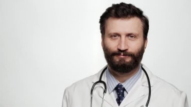 Doktor ekrandaki boş alanı işaret ediyor. Beyaz arka planda duran gülümseyen erkek doktor boş ekran alanını işaret ederek başını sallayarak onaylıyor.