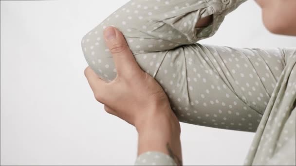 Armbågssmärta. Kvinnlig hand vidrör armbågen och försöker sträcka sina muskler och gemensamma på vit bakgrund. Närbild och slow motion — Stockvideo