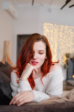 Genç kızıl saçlı kadın evde boş zaman geçiriyor. Sakin sabahlar. Huzurlu bir sabah kavramı ve fikri, bir hafta sonu meditasyon ve rahatlama