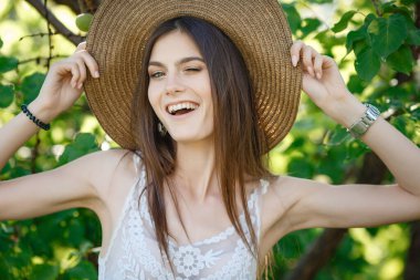 Yaz doğasında bahçeyle uğraşan güzel bir genç kadın. tapular ve bir yaz tuvaleti konsepti, yeşil bir bahçe ve özgürlük