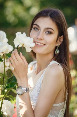 Yaz doğasında bahçeyle uğraşan güzel bir genç kadın. tapular ve bir yaz tuvaleti konsepti, yeşil bir bahçe ve özgürlük