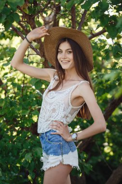 Yaz doğasında bahçeyle uğraşan güzel bir genç kadın. tapular ve bir yaz tuvaleti konsepti, yeşil bir bahçe ve özgürlük