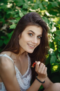 Yaz doğasında bahçeyle uğraşan güzel bir genç kadın. tapular ve bir yaz tuvaleti konsepti, yeşil bir bahçe ve özgürlük