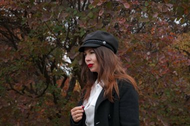 Sonbahar parkında orta yaşlı muhteşem bir kadının portresi. Merhaba Kasım ayı. Siyah paltolu şık bir yetişkin kadın mı? iş giyimi biçimi