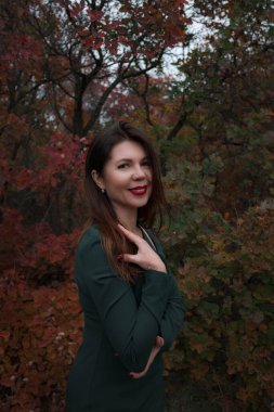 Sonbahar parkında orta yaşlı muhteşem bir kadının portresi. Merhaba Kasım ayı. Güzel elbiseli şık bir yetişkin kadın.