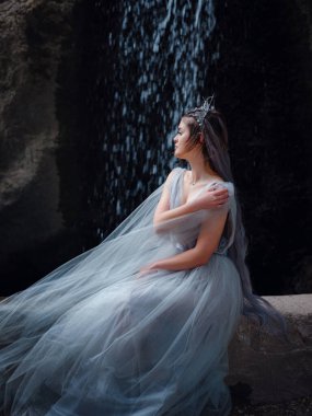 Parkta yürüyen peri ya da peri gibi güzel bir kadın. Peri masalı resim fotoğrafı. Parkın karanlığında güzel bir portre, Kanat gibi şelale jetleri