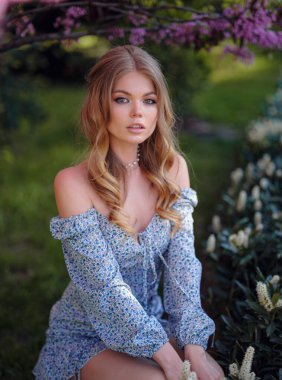 Mavi elbiseli güzel bir genç kadın bir yaz akşamı şehrinde yürüyor. Parkta çiçek açan ağaçların kokusundan hoşlanır.