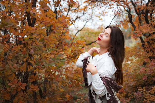 Portrait of a gorgeous middle-aged woman in an autumn park. Hello november. business casual