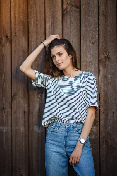 Retrato Uma Bela Jovem Morena Camisola Listrada Jeans Altos Contra — Fotografia de Stock