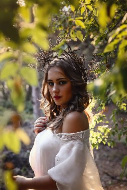 Sonbahar ormanında uzun beyaz elbiseli, gizemli gotik kadın. Karanlık fantezi yaratık