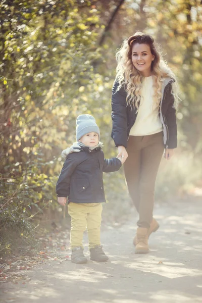 在一个阳光明媚的秋日 母亲和儿子正在户外散步 全家人都穿着秋装 快乐在一起 — 图库照片