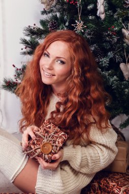attractive young woman in a winter fashion shot wearing a white woolen sweater and a knitted socks