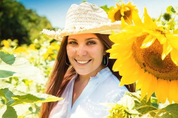 Junge schöne Frau zwischen Sonnenblumen — Stockfoto