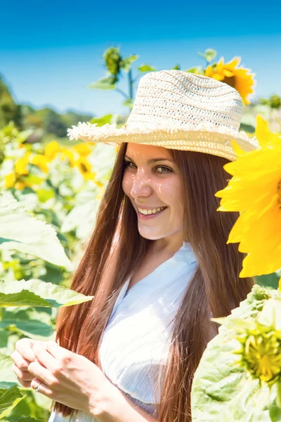 Junge schöne Frau zwischen Sonnenblumen — Stockfoto