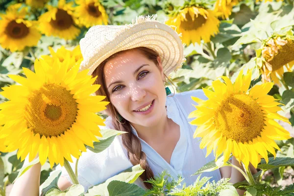 Junge schöne Frau zwischen Sonnenblumen — Stockfoto