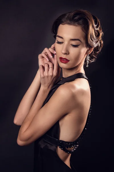 Elegant young woman in black lingerie posing at studio. — Stock Photo, Image