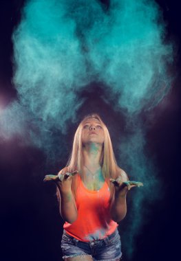 girl with colored powder exploding around her and into the background.
