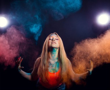 girl with colored powder exploding around her and into the background.