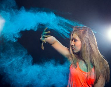 Girl with colored powder exploding around her and into the background.