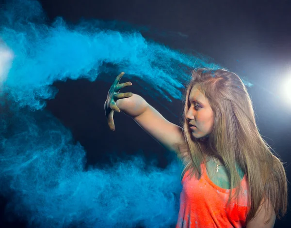 Girl with colored powder exploding around her and into the background. — Stockfoto