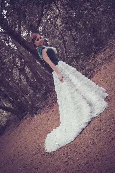 Uma mulher como uma princesa em um vestido vintage no parque de fadas — Fotografia de Stock