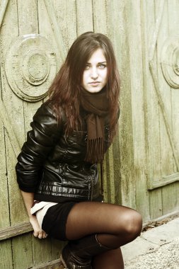 yakınındaki bir ağaç yaprakları bir yığın bir parkta oturan kız