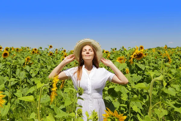 Junge schöne Frau auf blühendem Sonnenblumenfeld im Sommer — Stockfoto