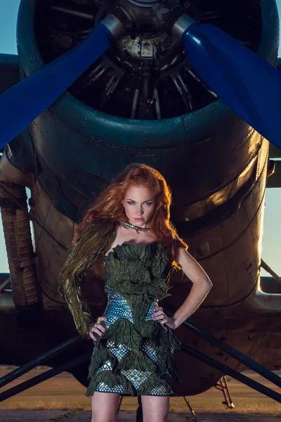 Vrouw met rood haar in militaire kleren in de buurt van het vliegtuig — Stockfoto