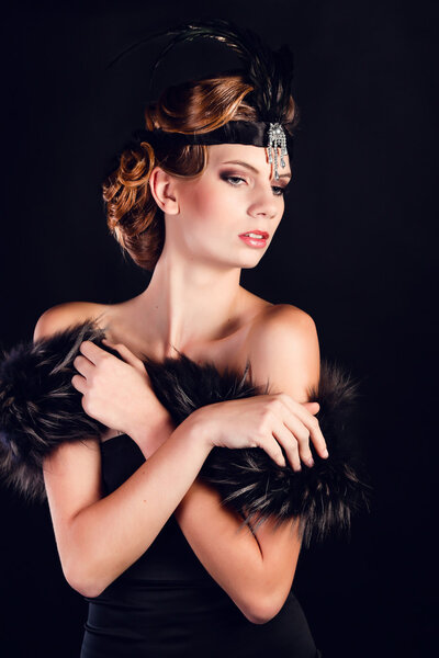 Elegant young woman in black lingerie posing at studio.