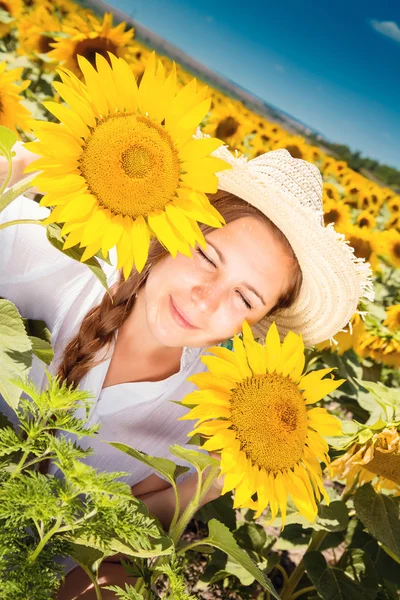 Junge schöne Frau zwischen Sonnenblumen — Stockfoto