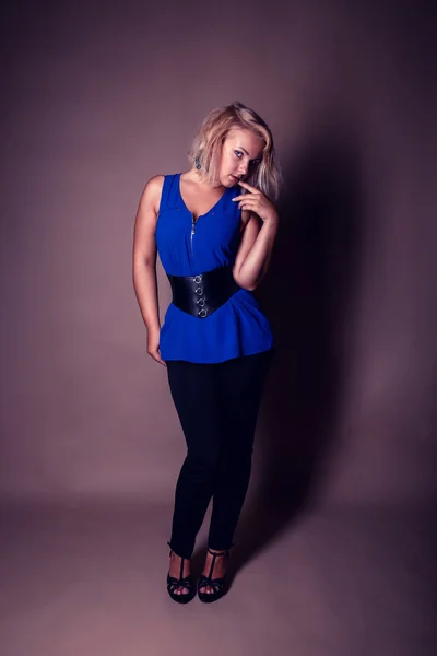 Retrato de bela encaracolado jovem loira posando em estúdio — Fotografia de Stock