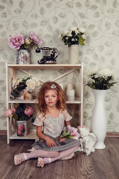 Cute little child girl with spring flowers — Stock Photo, Image
