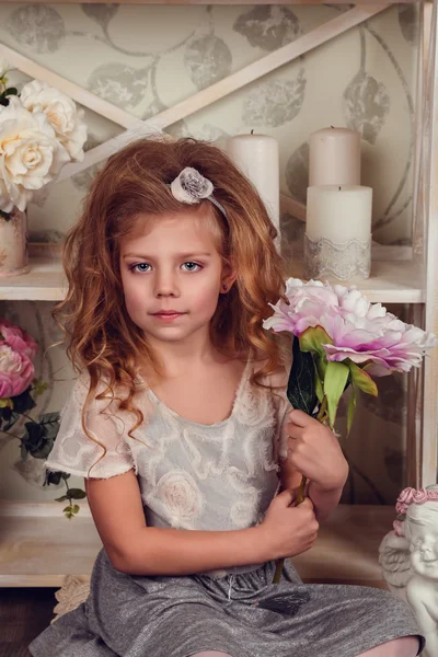 Cute little child girl with spring flowers — Stock Photo, Image