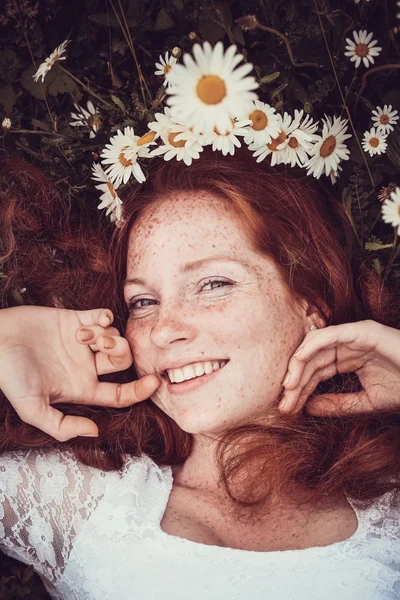 Imagen de una mujer bonita acostada en el campo de manzanilla, feliz femal — Foto de Stock