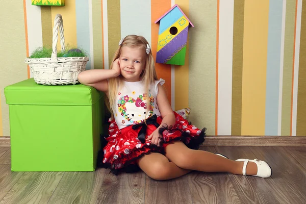 Portrait of a cute little girl dressed in dress  holding colorfu — Zdjęcie stockowe
