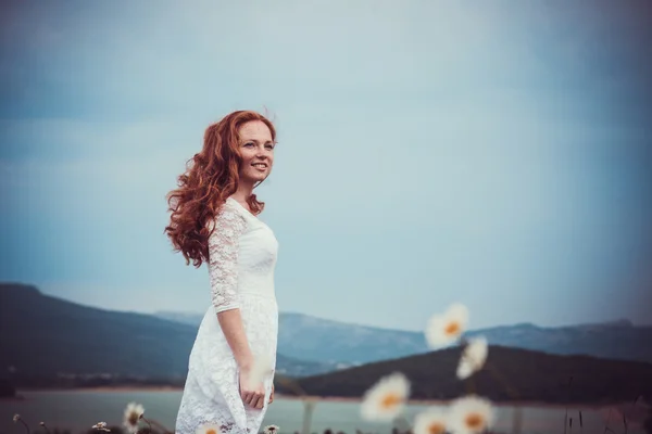 Bild einer hübschen Frau, die sich auf ein Kamillenfeld legt, eine glückliche Frau — Stockfoto