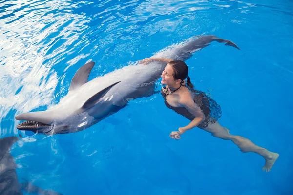 Mädchen schwimmt mit Delfin — Stockfoto