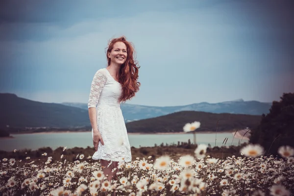 Immagine di bella donna sdraiata sul campo di camomilla, felice femminile — Foto Stock