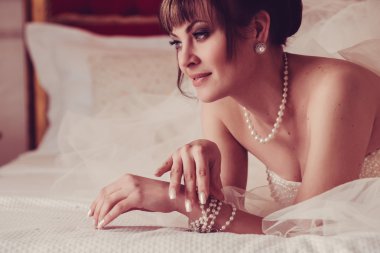 güzel genç gelin düğün makyaj ve saç yatak, yeni evli kadın son hazırlık ve sunuş düğün için ile. mutlu gelin bekleyen damat. evlilik gün an düğün. Gelin portre yumuşak odak