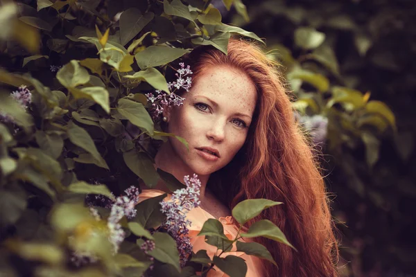 Krásné ženy těší Lila zahrada, mladé ženy s květinami v zelený park. Veselá teenagery chůzi venkovní. měkké světlo styl barva — Stock fotografie