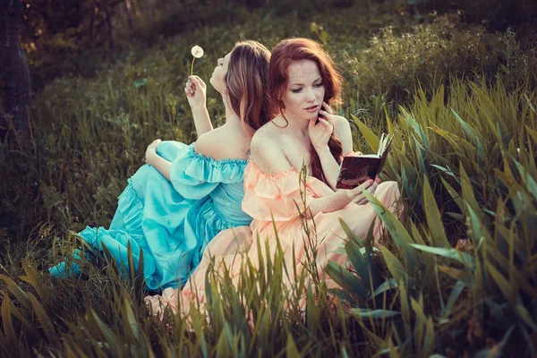 Beautiful women enjoying lilac garden, young women with flowers in green park. cheerful teenagers walking outdoor. soft light style color — Stock Photo, Image