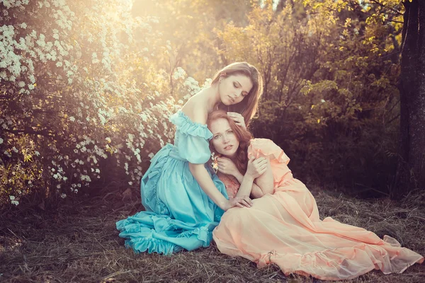 Hermosas mujeres disfrutando de jardín lila, mujeres jóvenes con flores —  Fotos de Stock