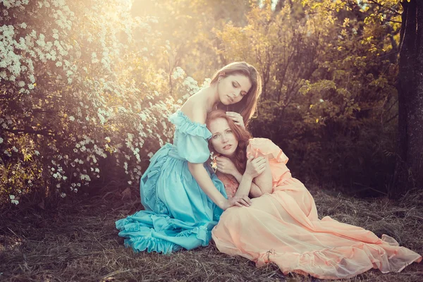 Belles femmes appréciant le jardin lilas, jeunes femmes avec des fleurs — Photo