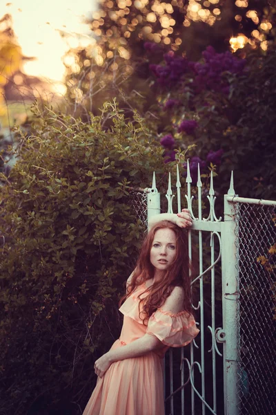 Hermosas mujeres disfrutando de jardín lila, mujeres jóvenes con flores —  Fotos de Stock
