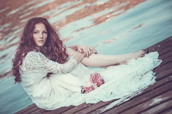 Portret van een jonge vrouw in de de lentetijd. Amandel bloemen bloeit. Meisje gekleed in het wit als een bruid. — Stockfoto