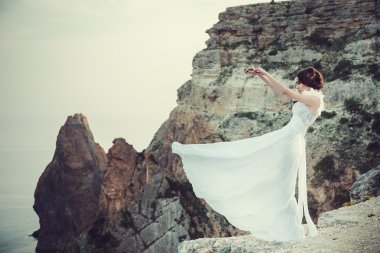 Güzel gelin melek elbise ile sahilde poz